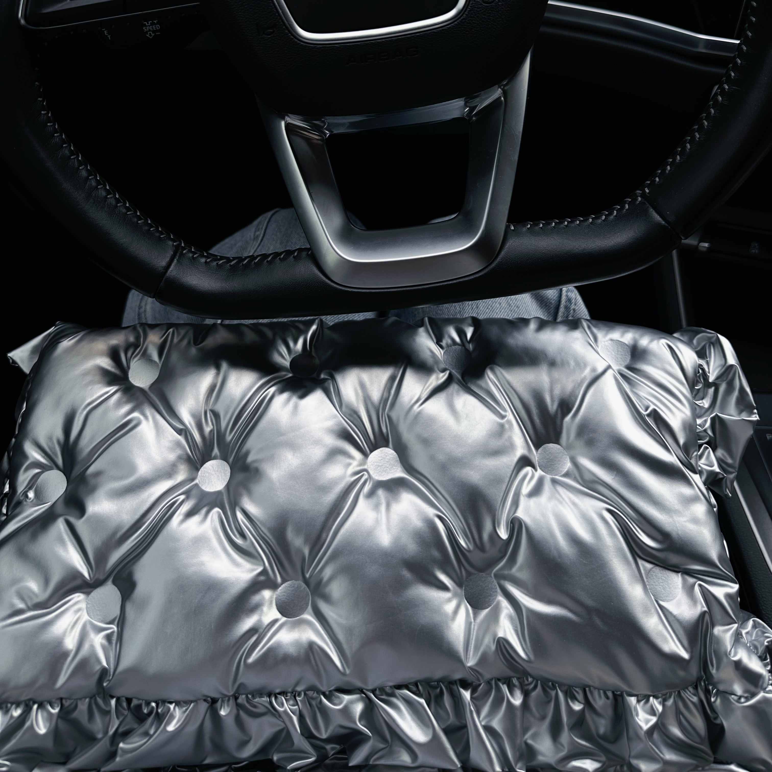 Silver Ruffle Graphene Hand Warmer | Portable USB Heating Bag placed on a car seat, featuring a soft quilted metallic silver surface with ruffle detailing, designed for portable warmth during travel, office use, and outdoor activities.